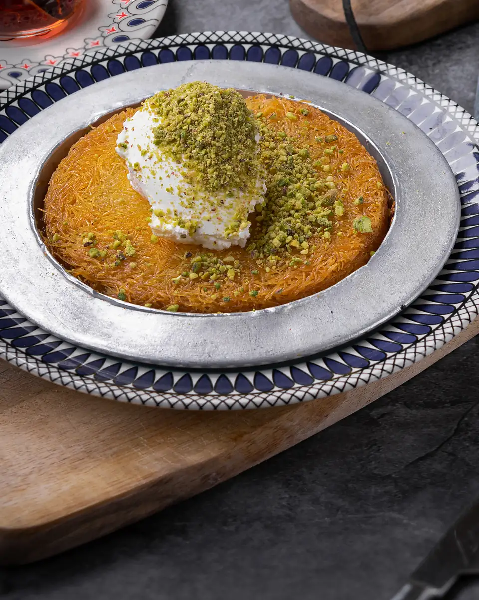 Künefe aus dem Café Peri Berlin: warmer Teigfaden-Kuchen mit Käsefüllung, mit Kaymak und gehackten Pistazien.