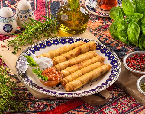 Sigara Böreği – knusprige türkische Börek-Röllchen mit Käsefüllung, serviert mit Joghurt- und Tomatendip im Café Peri Berlin.