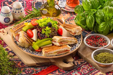 Türkischer Tost – gegrilltes Sandwich mit Käse und Sucuk, dazu Salat, Oliven und Weißkäse, im Café Peri Berlin-Schöneberg.